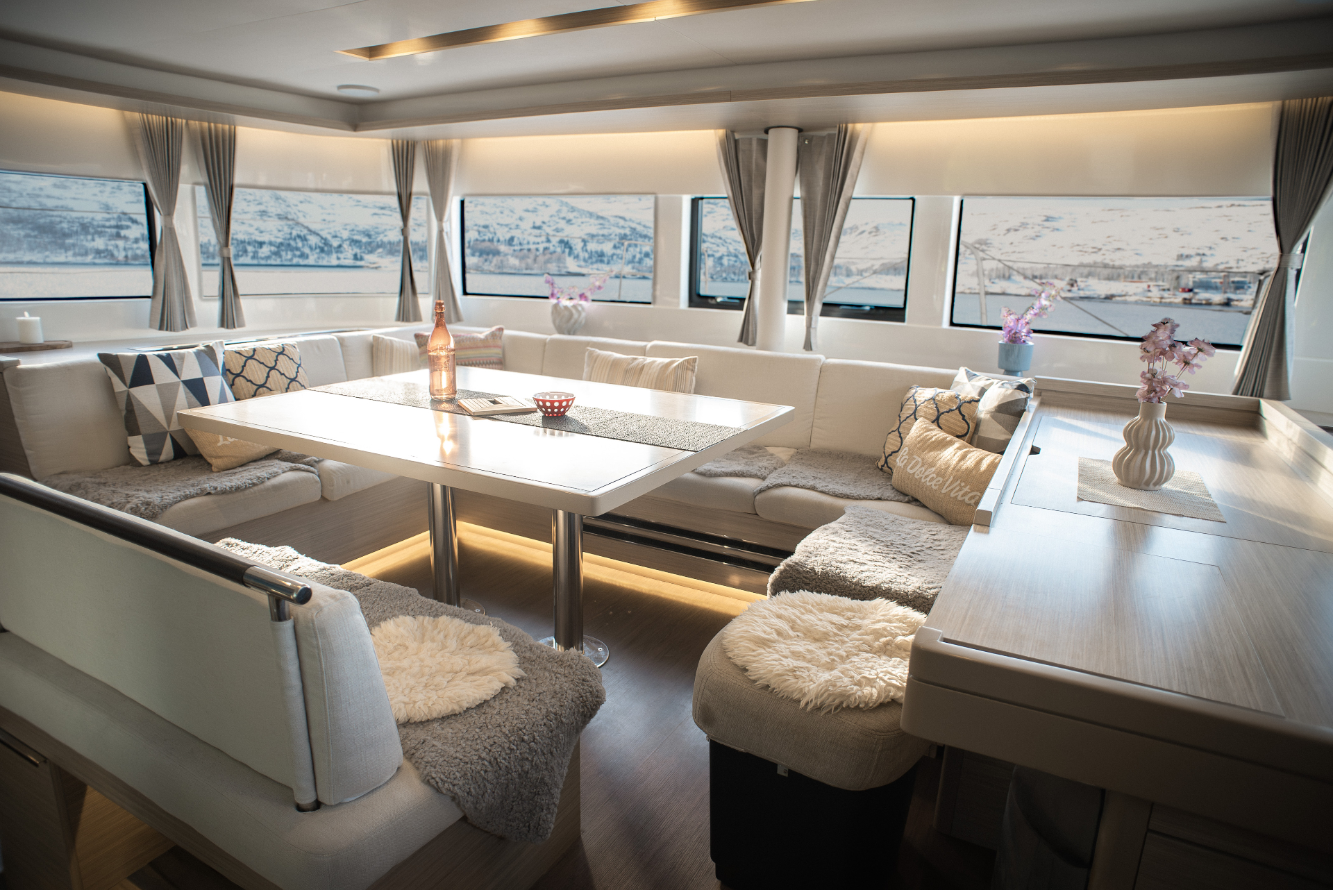Warmly lit saloon interior with fjord views