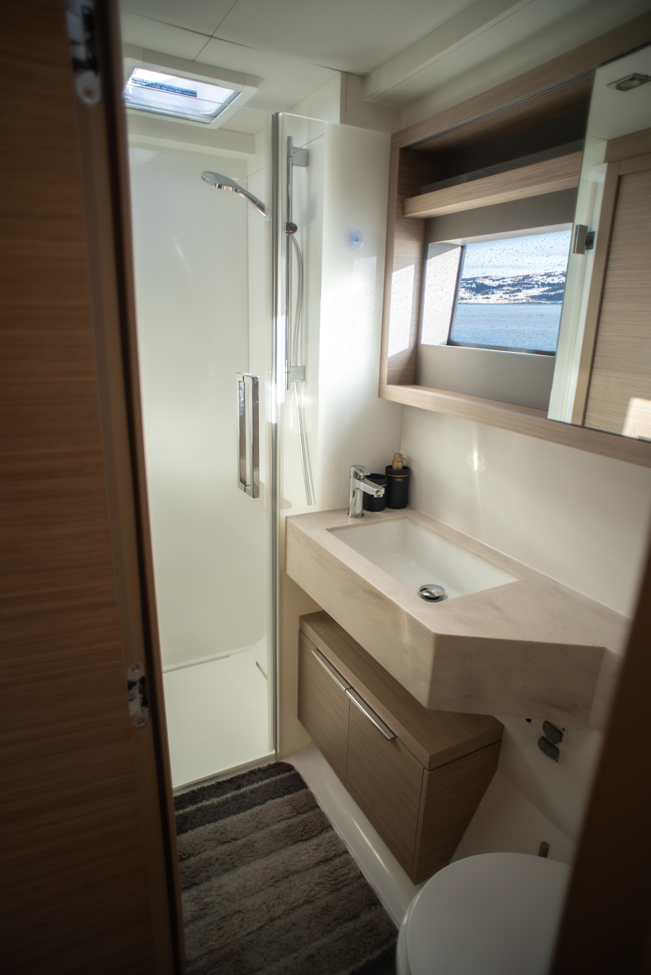 En-suite head with separate shower stall, stone basin and skylight